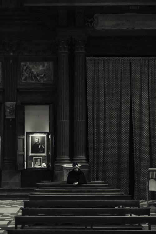 Free A person sits alone in a dimly lit church, evoking solitude and reflection. Stock Photo