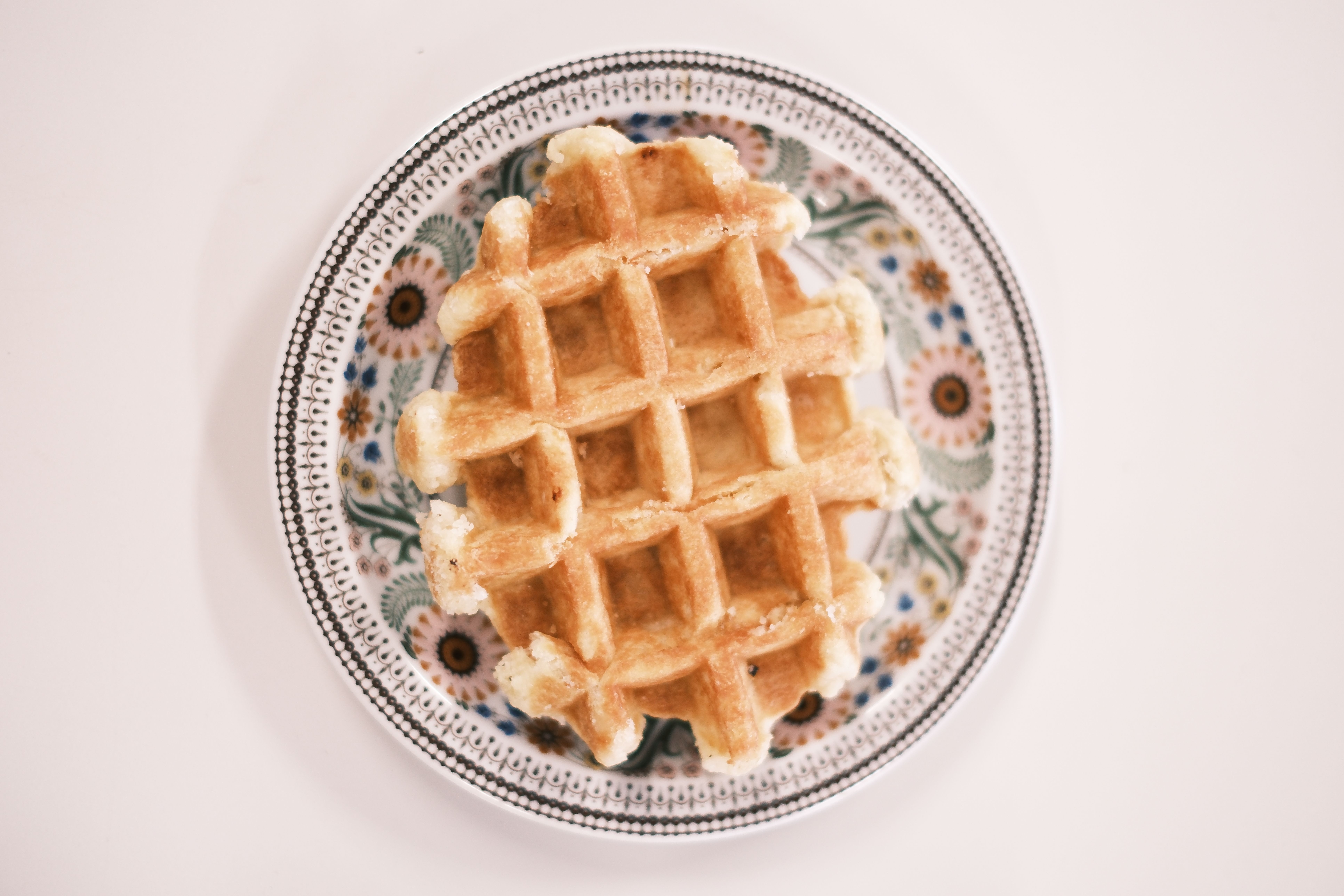 Delicious waffle on a floral patterned plate, perfect for breakfast themes.
