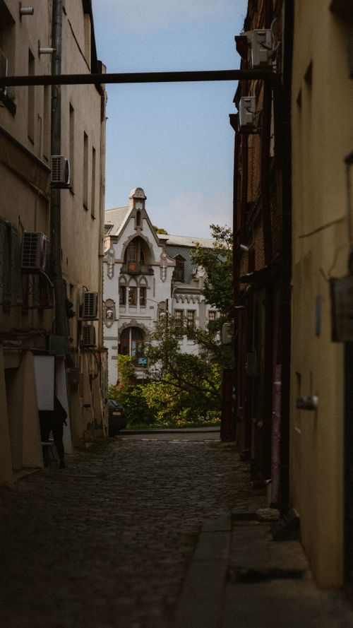 Free A picturesque view of a historic building through a quaint Tbilisi alleyway, showcasing unique architecture. Stock Photo