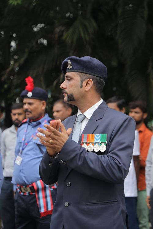 Free Man in formal uniform with medals, applauding at an outdoor ceremony. Stock Photo