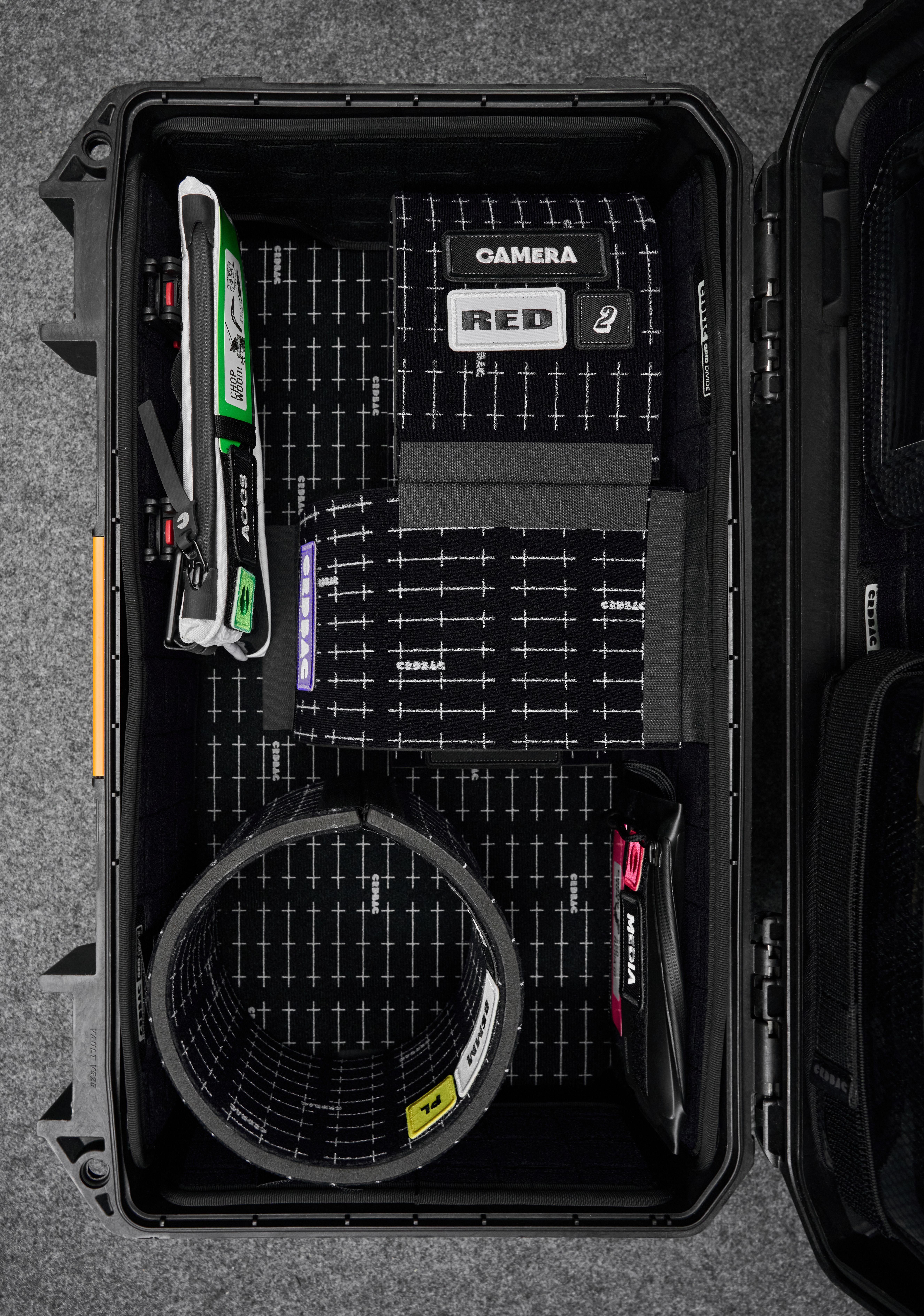 A hard shell case protecting a camera and other tech items.
