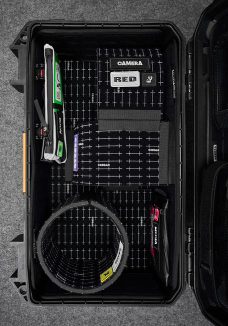 A hard shell case protecting a camera and other tech items.