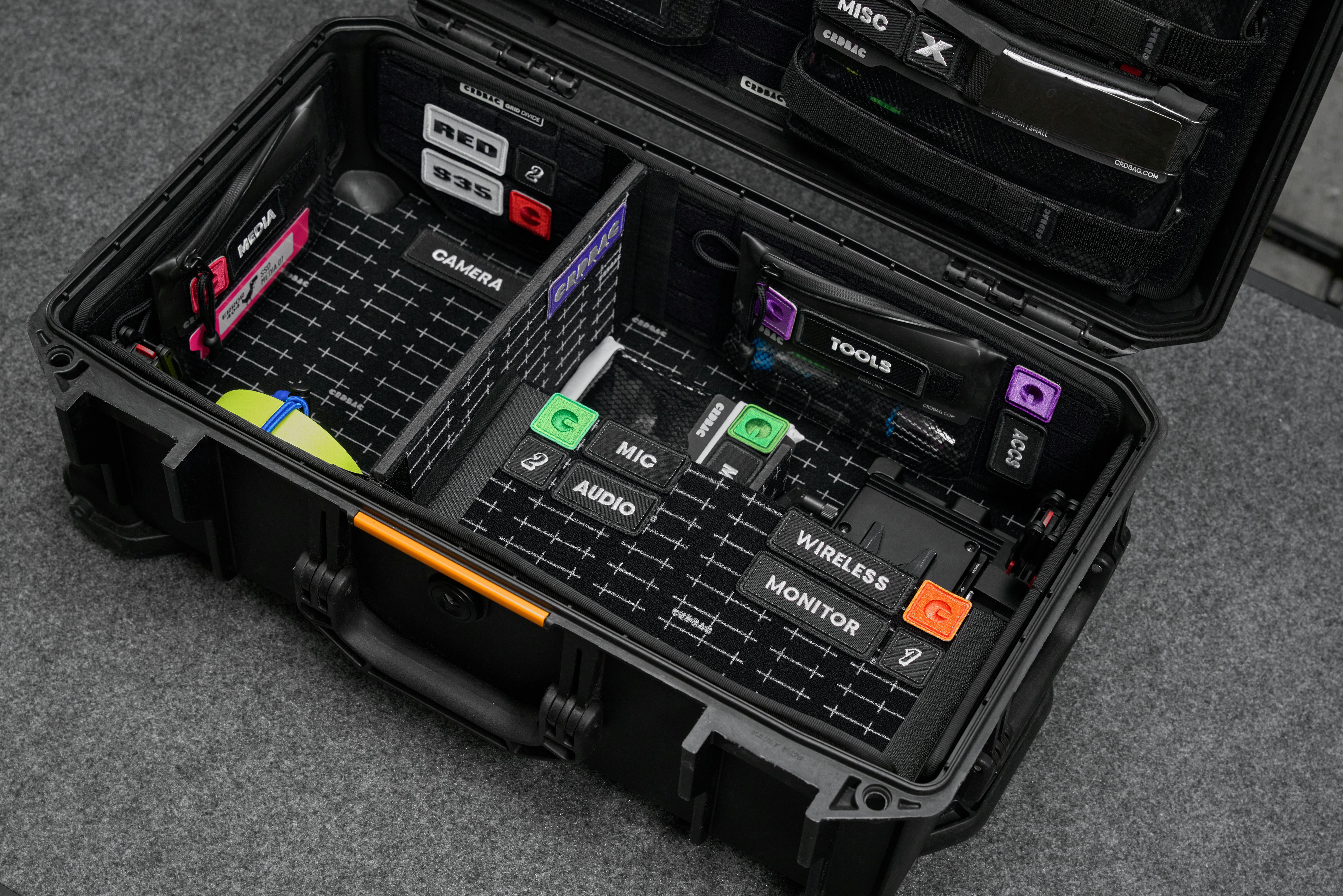 Black hard case with organized DSLR equipment including camera, mic, monitor, and tools.