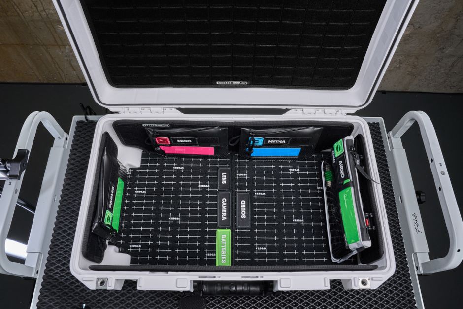 Matériel photo protégé pour milieu humide Top view of a neatly organized camera equipment hard case with labeled compartments.