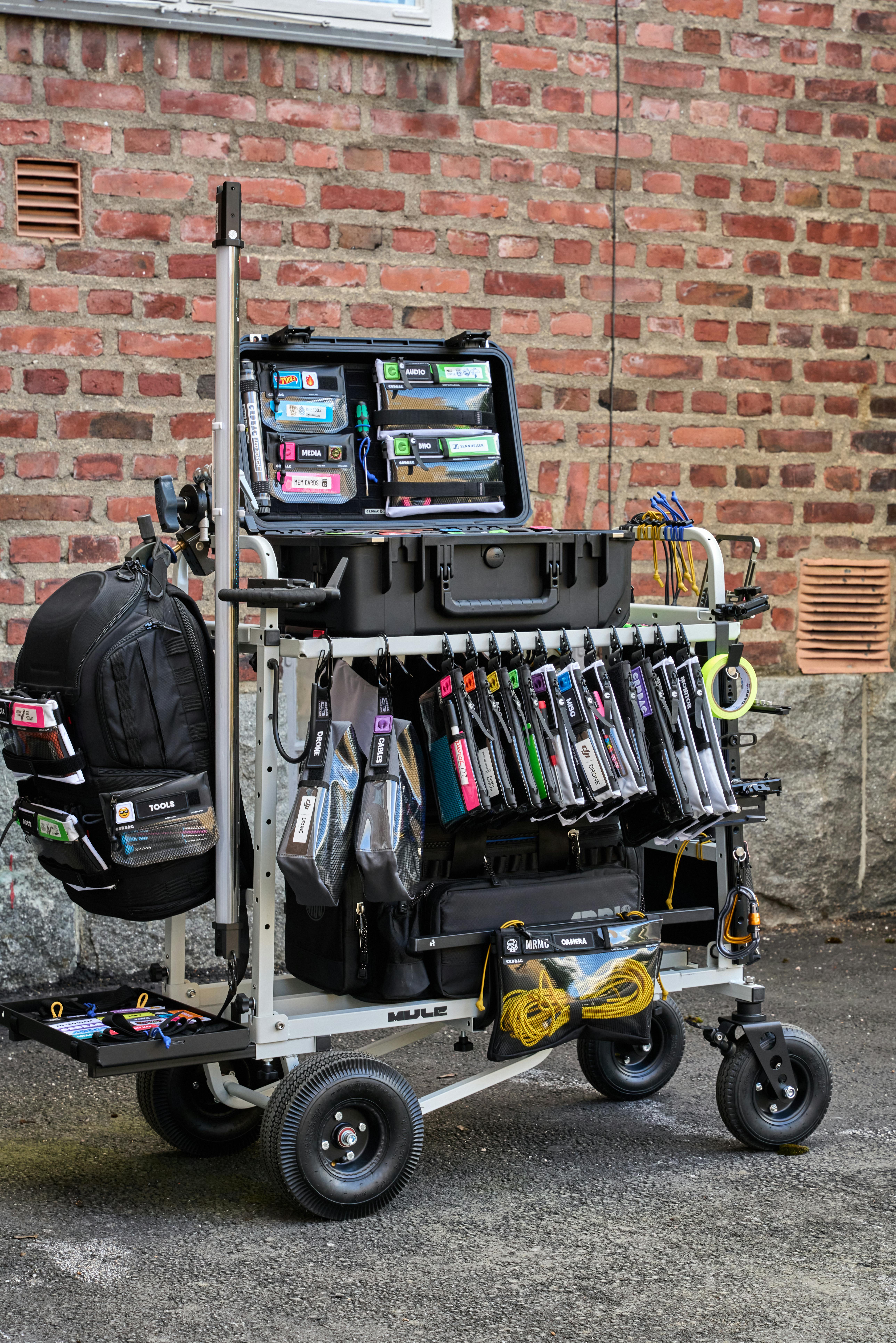 Mobile cart with film equipment against a brick wall outdoors in Sundsvall, Sweden.