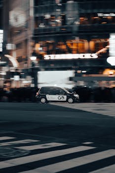 Blurred car motion in vibrant Shibuya at night, capturing Tokyo's lively street atmosphere.