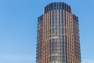 清澈的蓝天下，矗立着一座高大的现代玻璃建筑