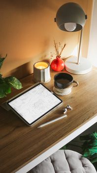 Inviting home workspace setup with a tablet, coffee, lamp, and decor for creativity.