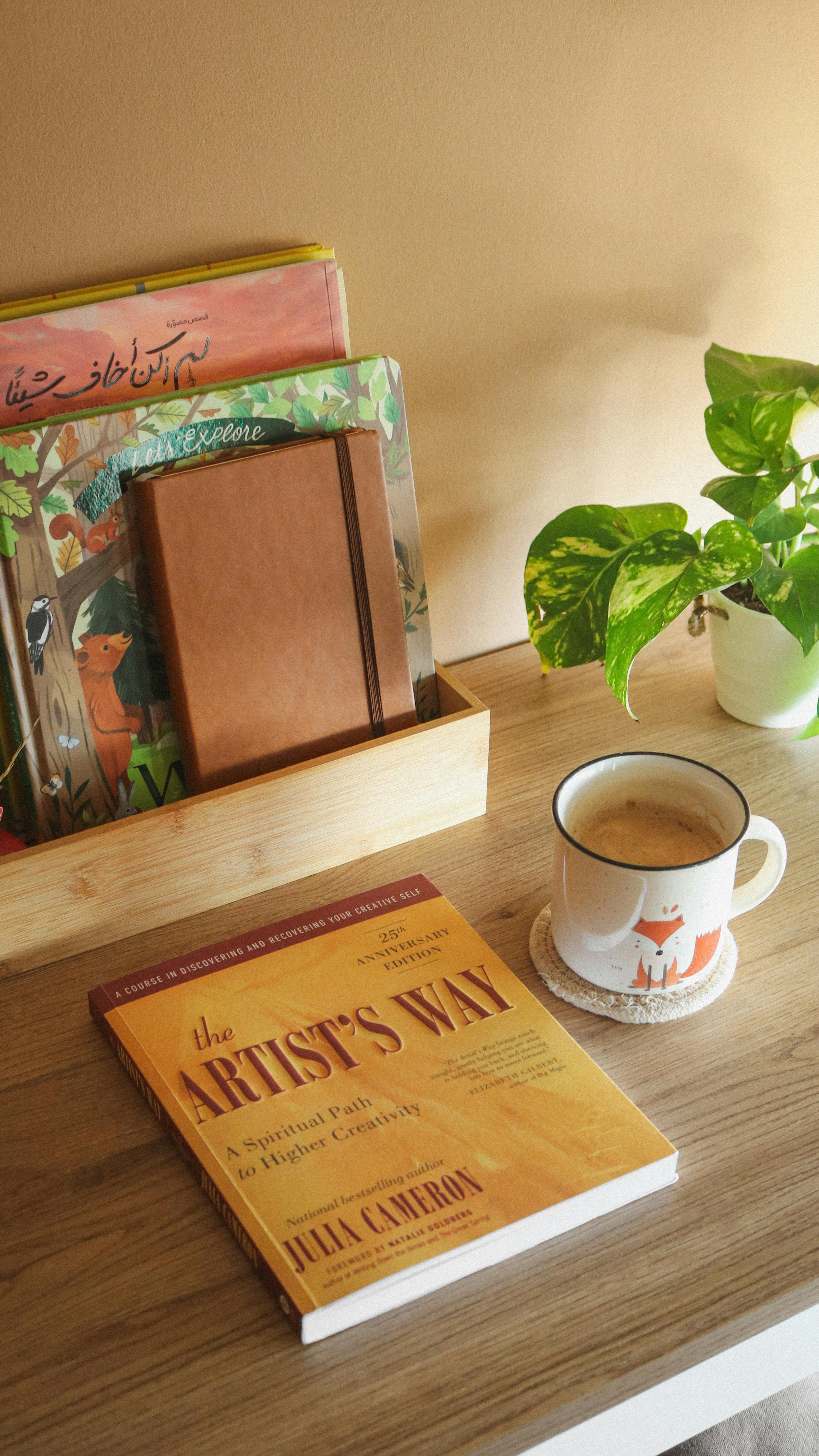 Warm and inviting reading nook featuring books, a coffee mug, and a plant on a wooden table.