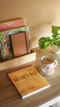 Warm and inviting reading nook featuring books, a coffee mug, and a plant on a wooden table.