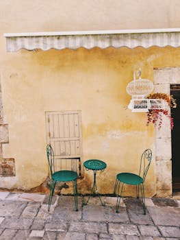 Idyllic outdoor café setting with vintage green chairs in Valbonne, Provence.