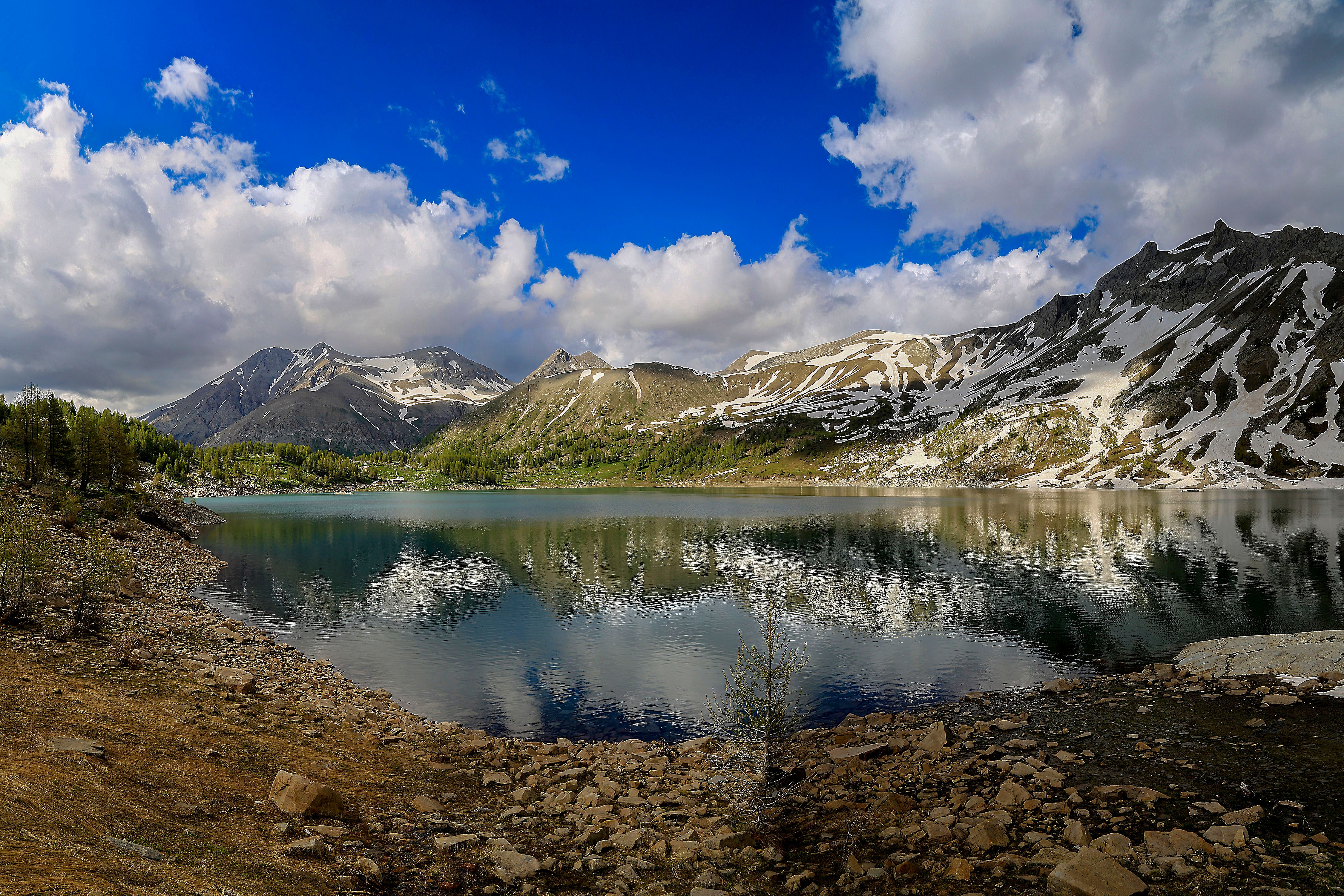 Breathtaking view of a mountain lake with snow-capped peaks in Allos, France.