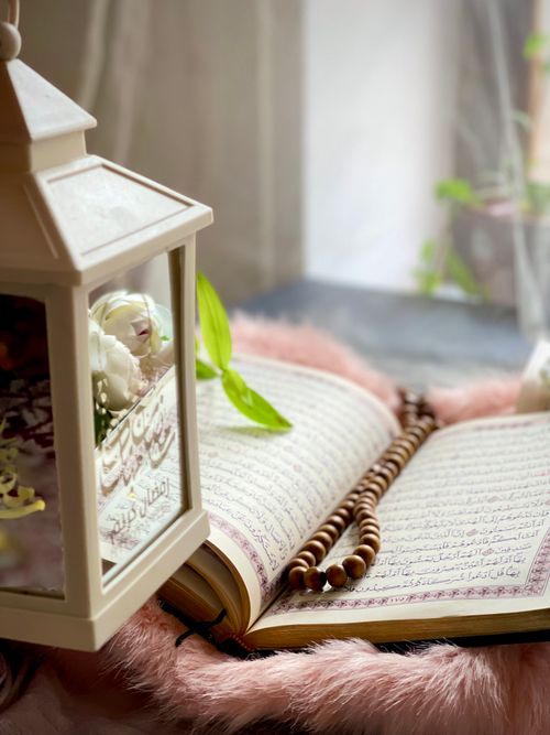 Free Open book with prayer beads beside a decorative lantern, exuding a peaceful and spiritual ambiance. Stock Photo