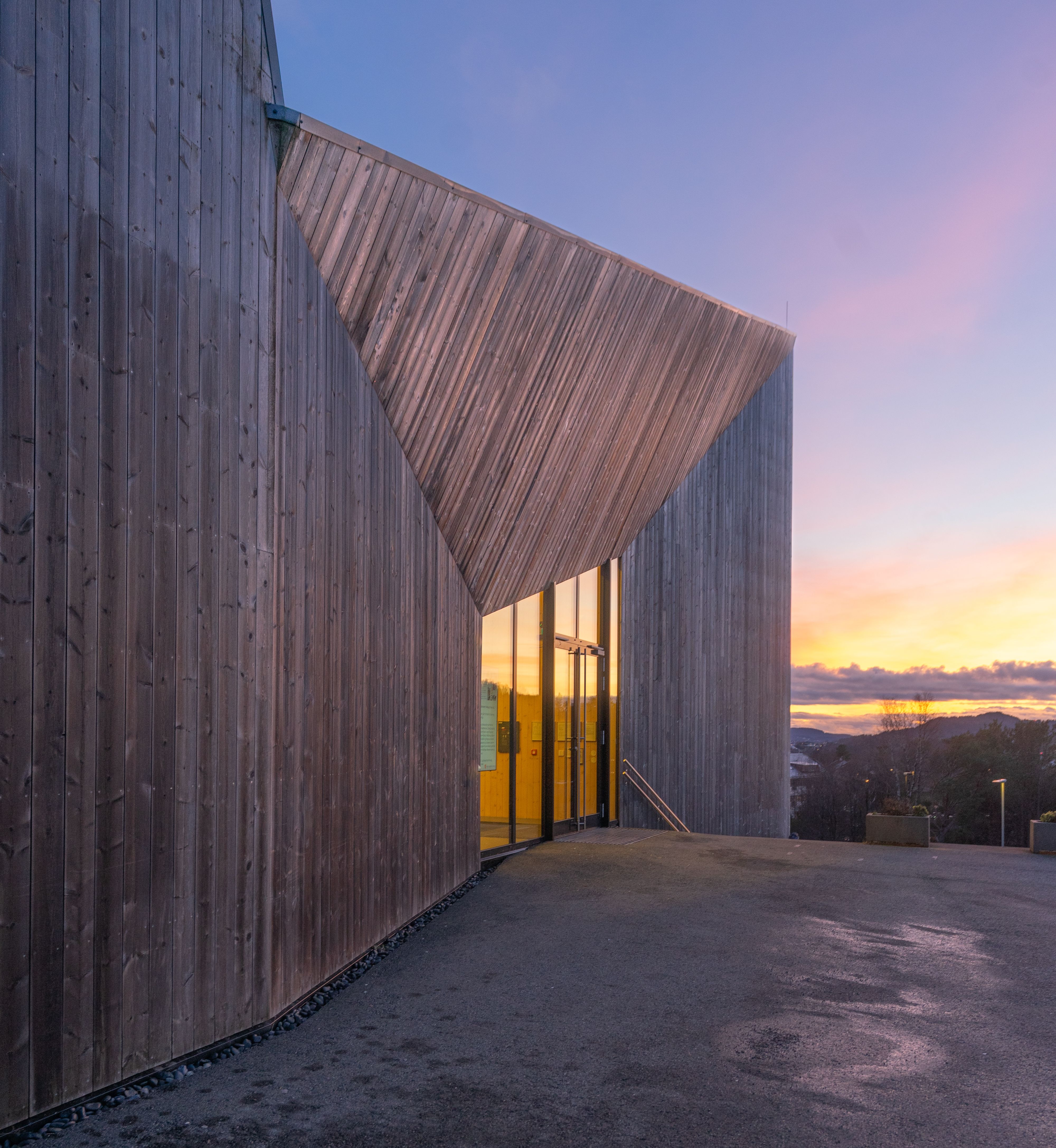 Contemporary wooden building exterior at sunset with vibrant sky.