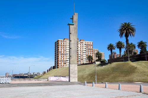 Free A striking concrete monument with palm trees and buildings in Montevideo, Uruguay. Stock Photo