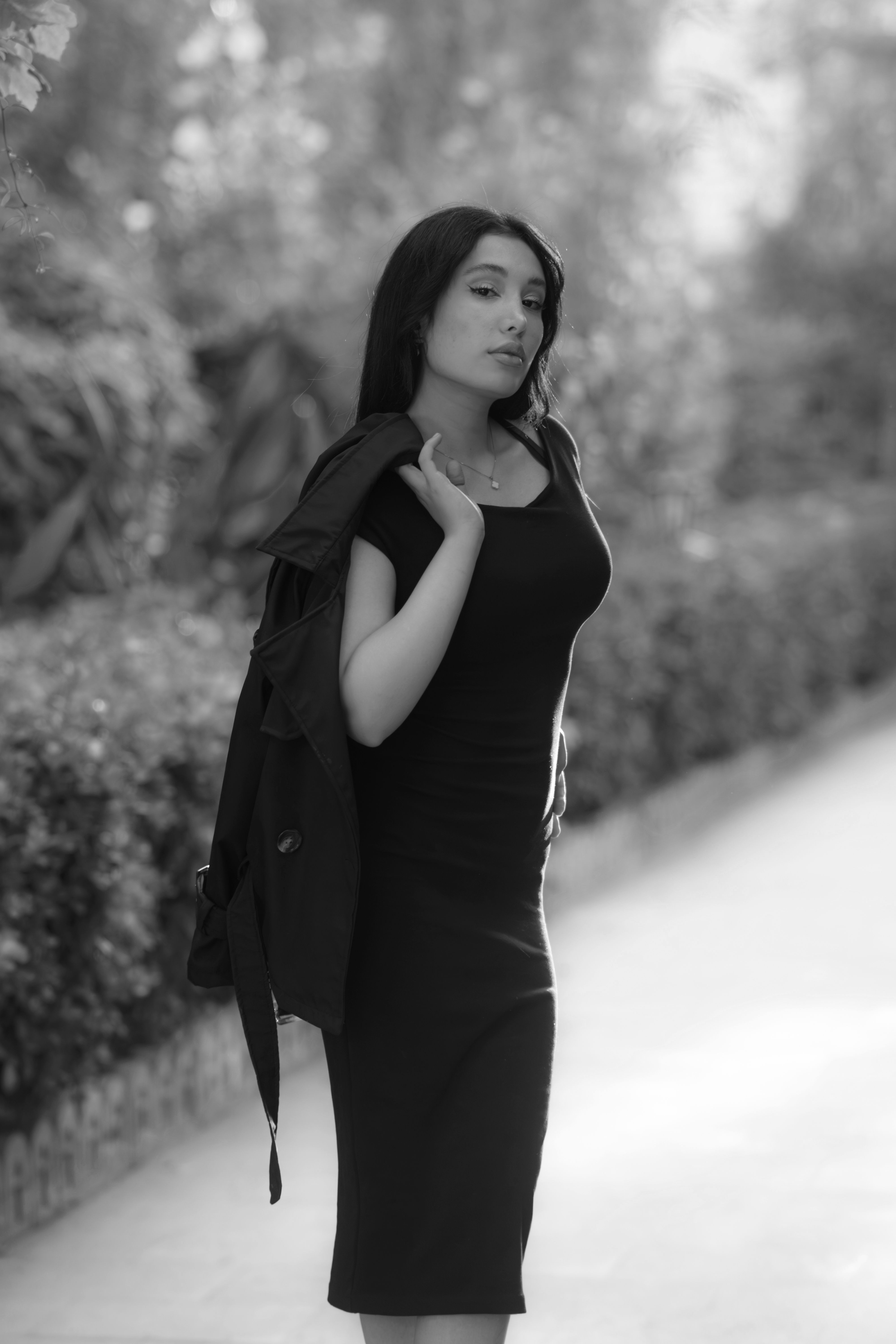 Elegant Woman in Black Dress Walking Outdoors · Free Stock Photo