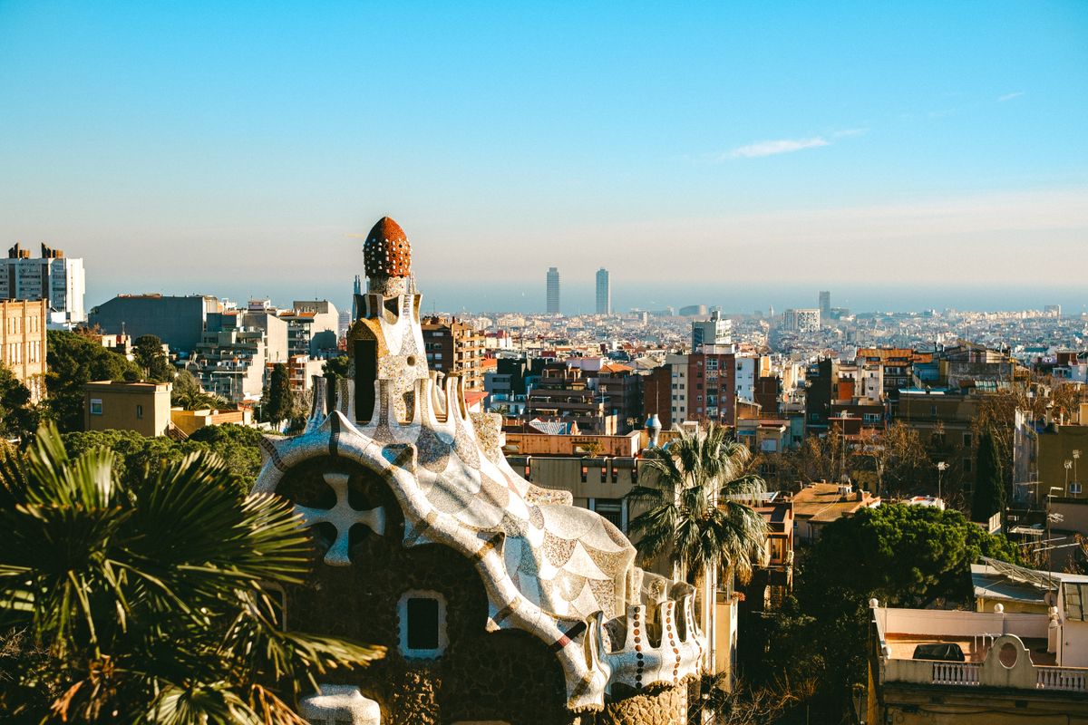 Panorama din Park Güell, cu arhitectura lui Gaudí în prim-plan și orașul Barcelona în fundal