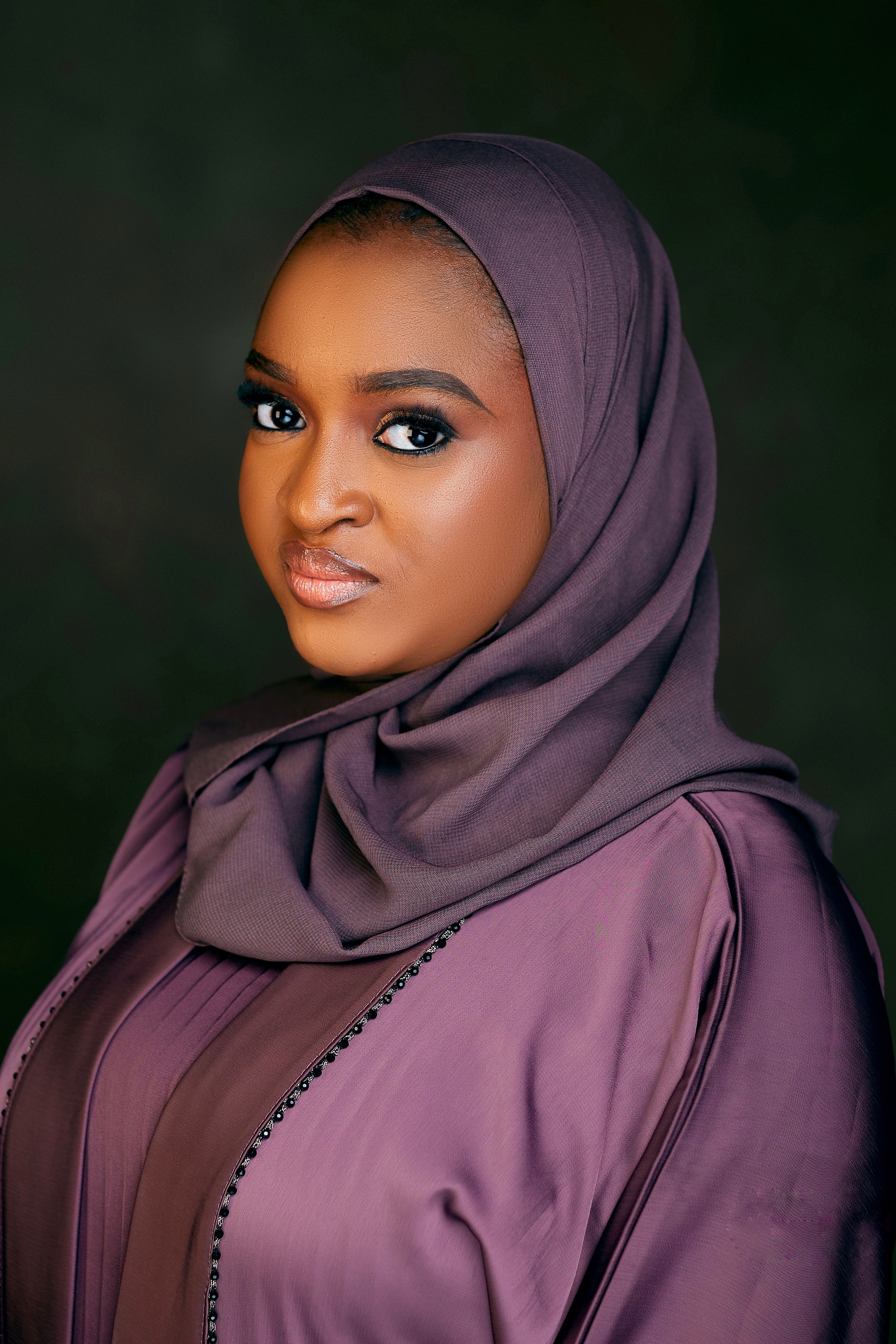 Beautiful portrait of a woman wearing a purple hijab, exuding elegance and confidence.