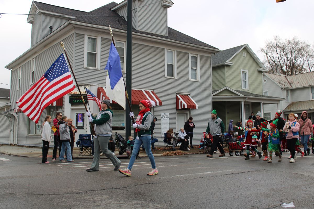 Festive small-town holiday parade with American flags and community gathering