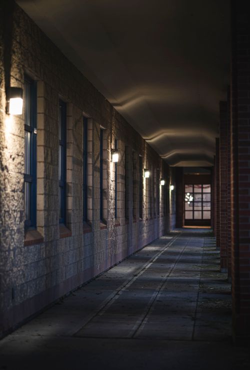 Free Moody indoor corridor with brick and stone walls illuminated by dim lighting creating a mysterious atmosphere. Stock Photo