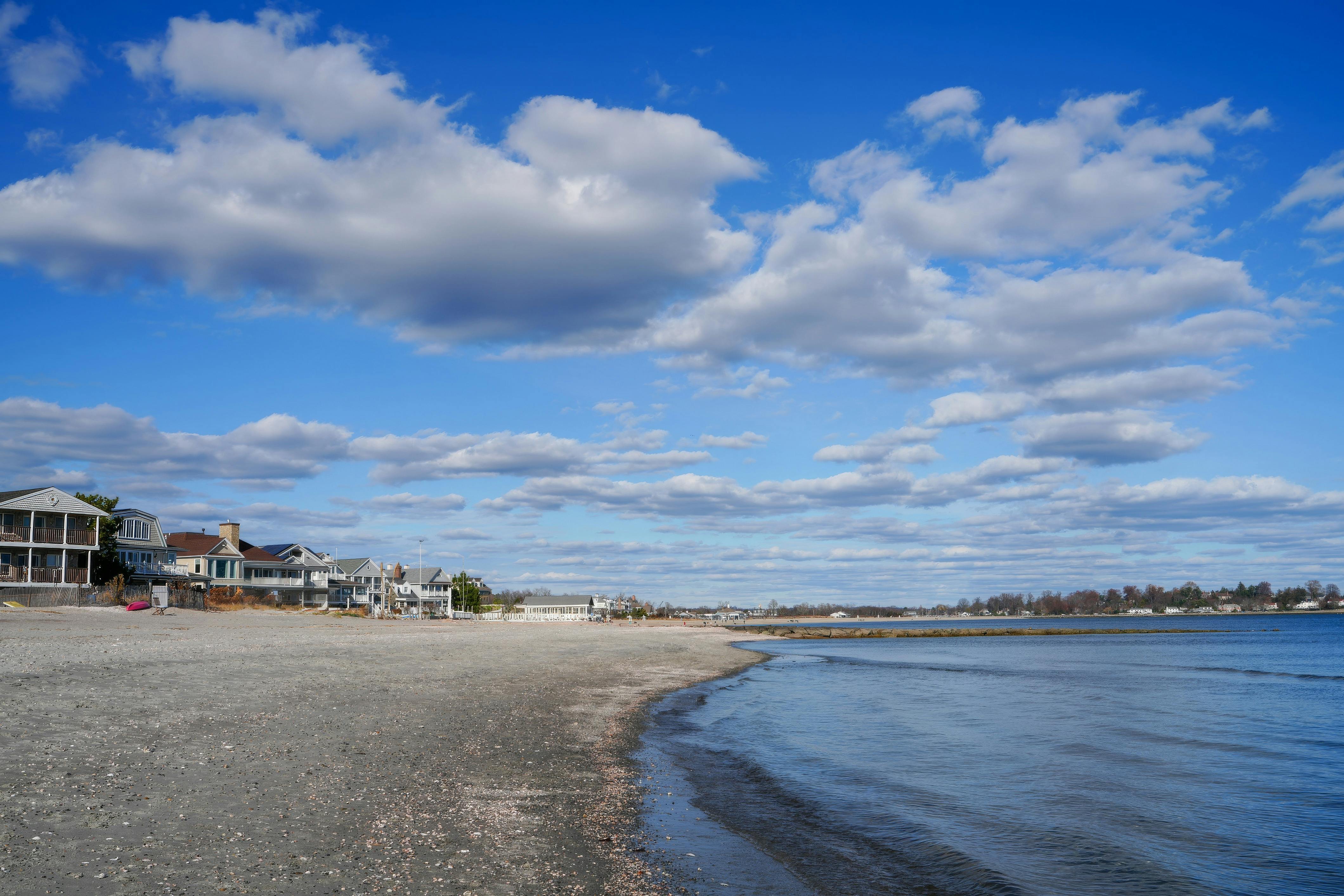 Beautiful coastal scene with beach houses and a blue sky filled with clouds. - Photo by Cara Denison on Pexels