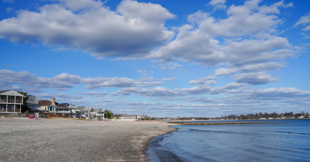 Beautiful coastal scene with beach houses and a blue sky filled with clouds.