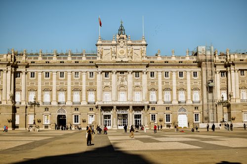 Free The magnificent Royal Palace of Madrid, captured on a sunny day with visitors outside. Stock Photo