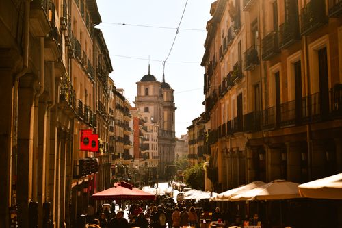Free A busy European street with classic architecture and lively atmosphere under warm afternoon sunlight. Stock Photo