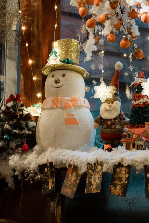 Free Charming snowman with festive decorations in a cozy holiday setting. Stock Photo