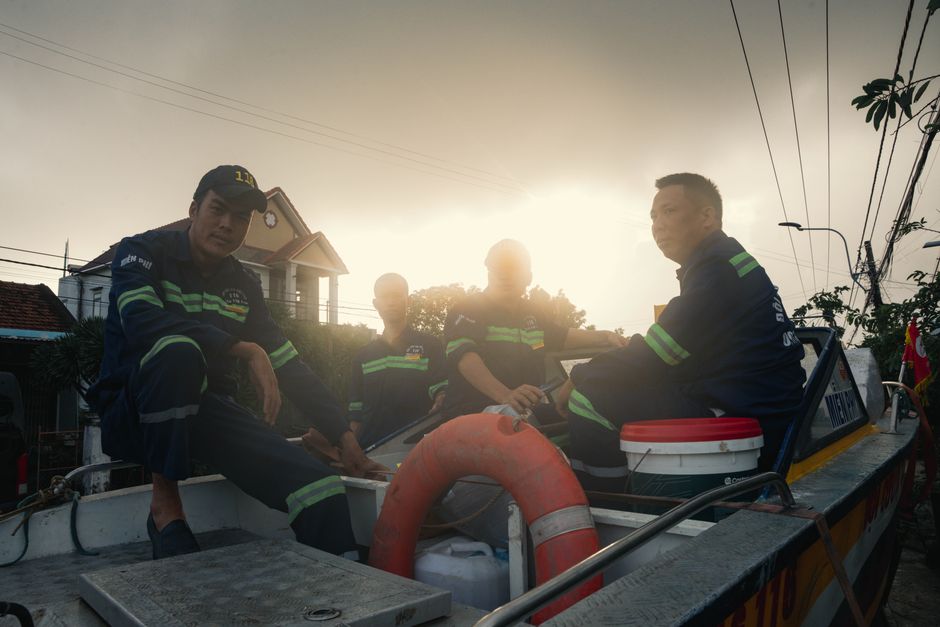 Rescue workers in uniform on a boat at sunset in Phú Yên, Vietnam