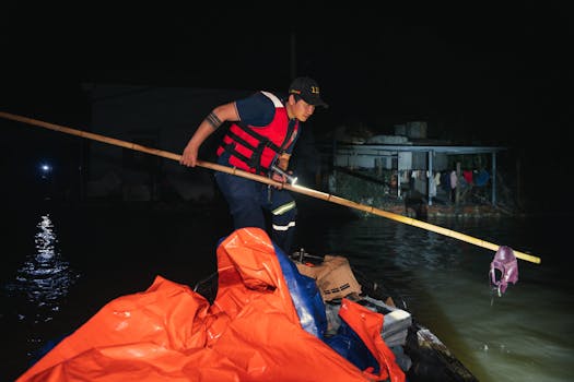 Un soccorritore a Phú Yên, in Vietnam, aiuta le vittime dell'alluvione durante le operazioni notturne.