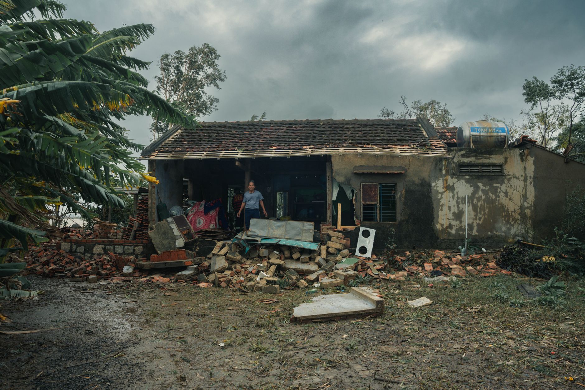 A rural house in Phú Yên, Vietnam, heavily damaged by a storm, showcasing nature's impact.