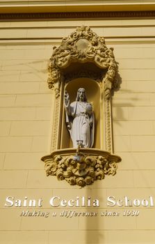 Ornate religious statue above Saint Cecilia School entrance.