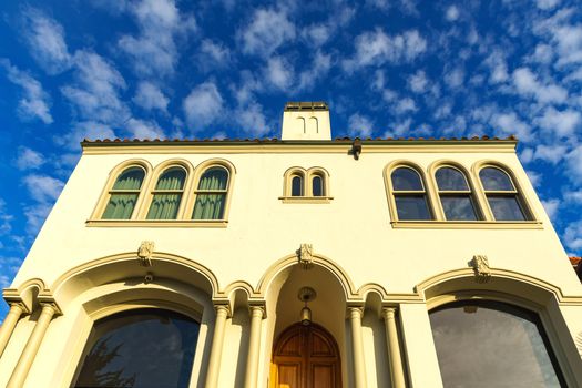 Stunning Mediterranean-style building facade with arched windows against a bright blue sky.