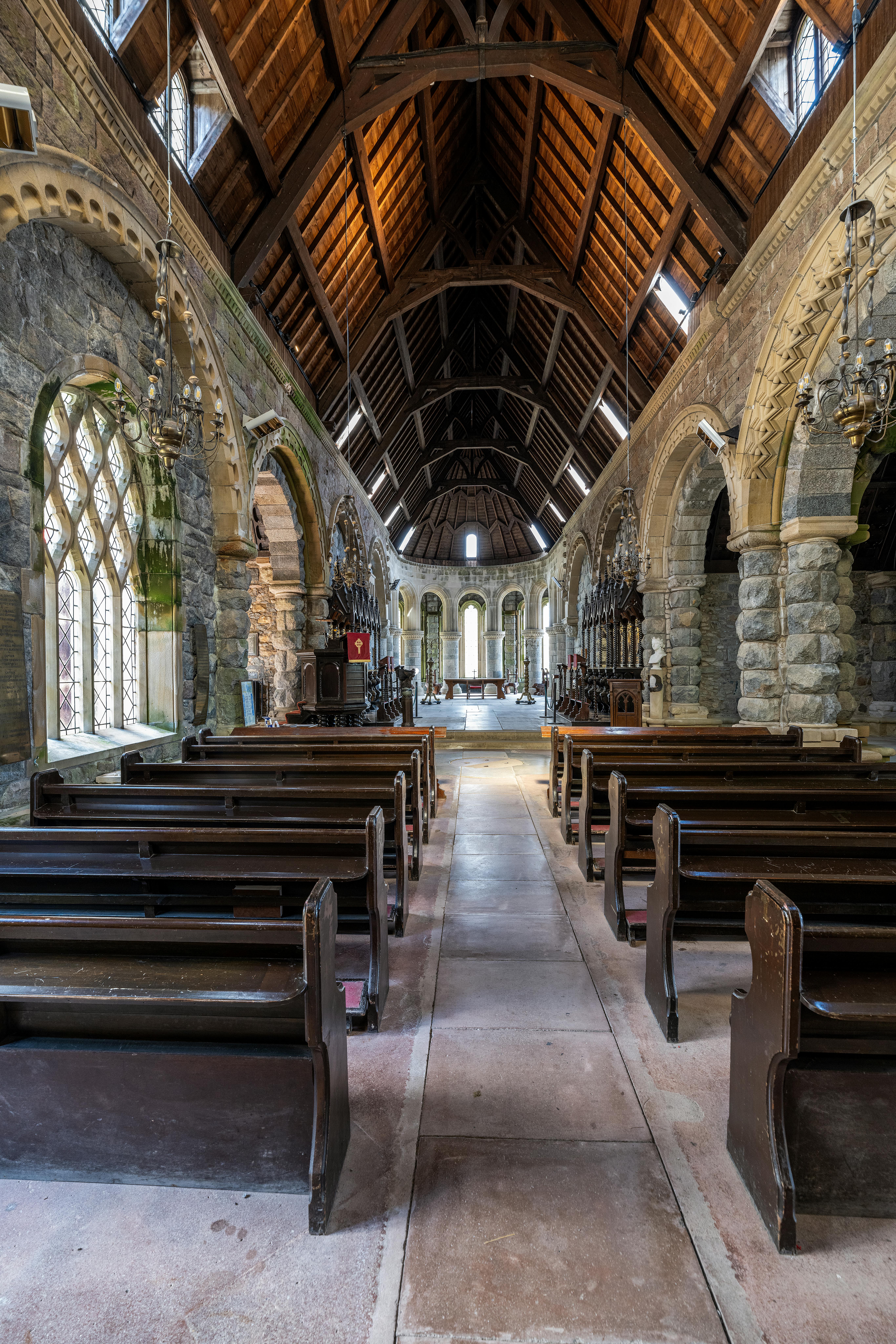 Historic stone church interior with wooden roof and arched windows