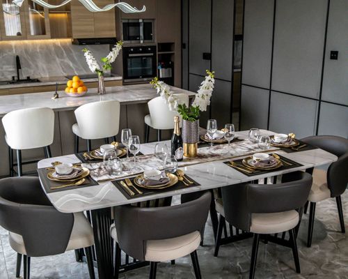 Free Sophisticated dining table setup with modern kitchen background, perfect for gatherings. Stock Photo