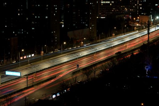 Vibrant streaks of urban highway traffic lights at night, captured in long exposure.