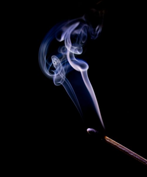 Free Captivating image of a smoking matchstick with swirling patterns against a black backdrop. Stock Photo