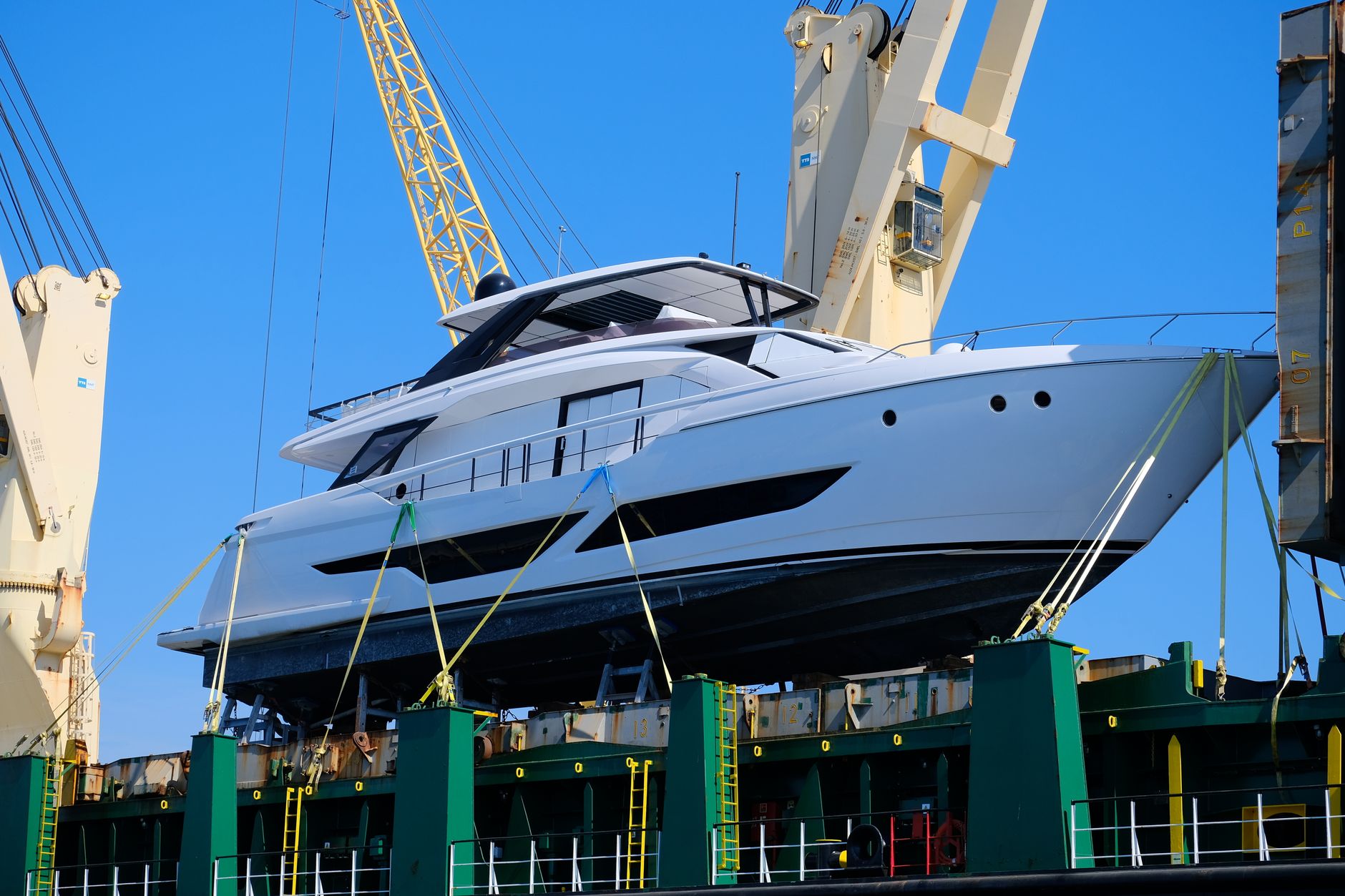 Yacht bianco issato da una gru — alaggio prima del carico in container