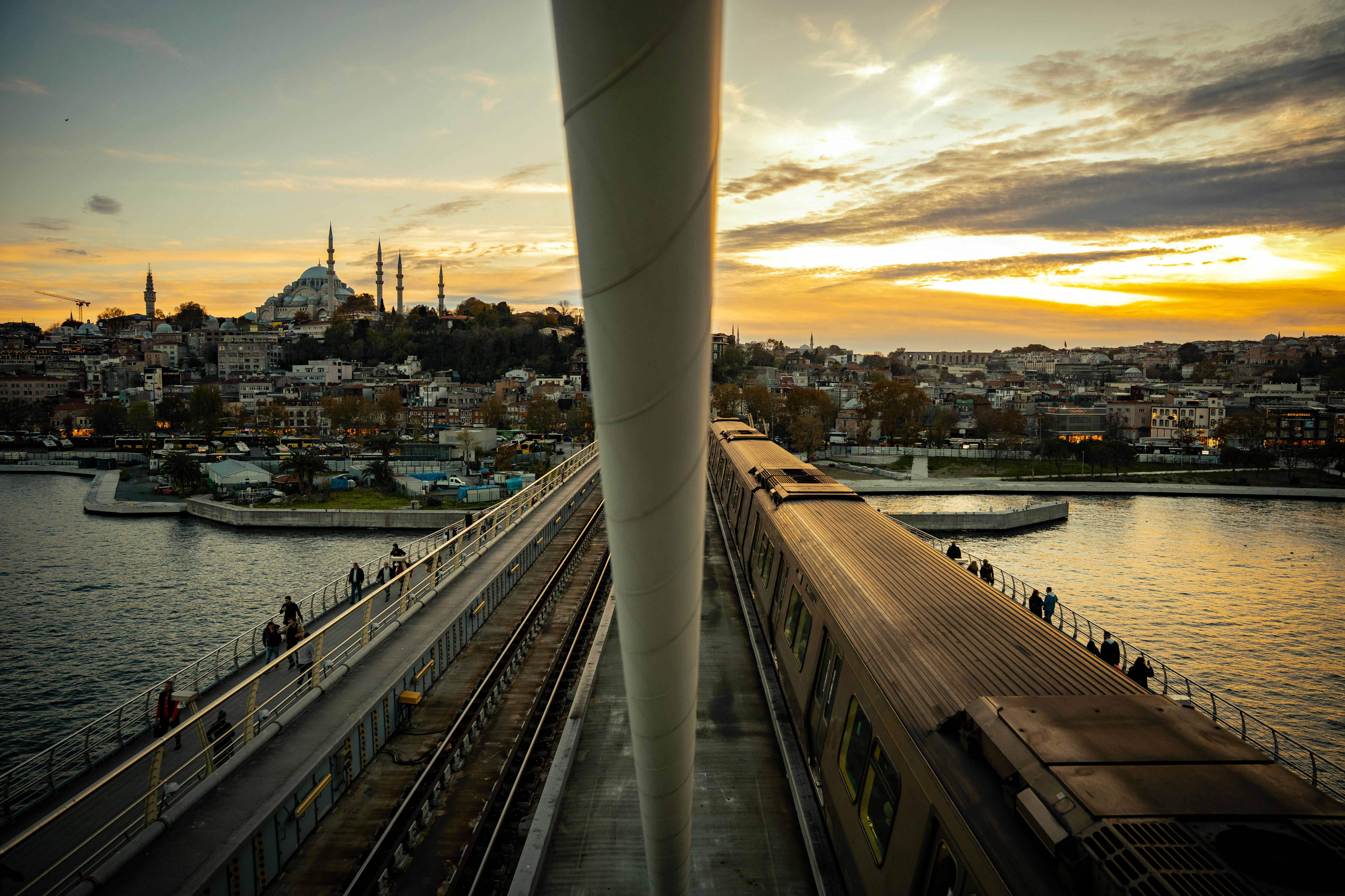 Gratuit Vue panoramique du pont du métro de la Corne d'Or au coucher du soleil, avec la silhouette d'Istanbul en arrière-plan. Photos