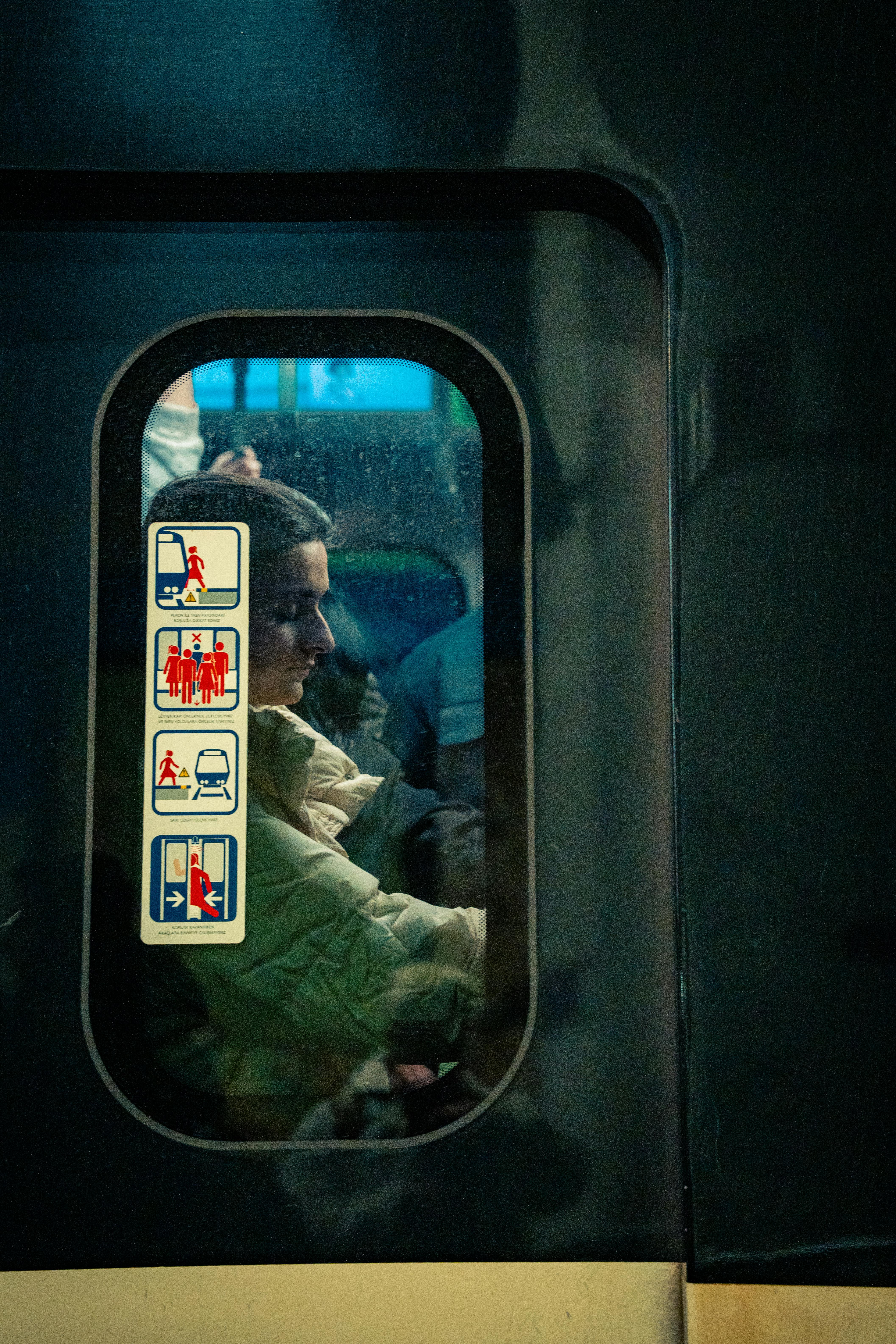 grátis Um homem visto através da janela pouco iluminada de um trem durante o trajeto noturno. Foto profissional