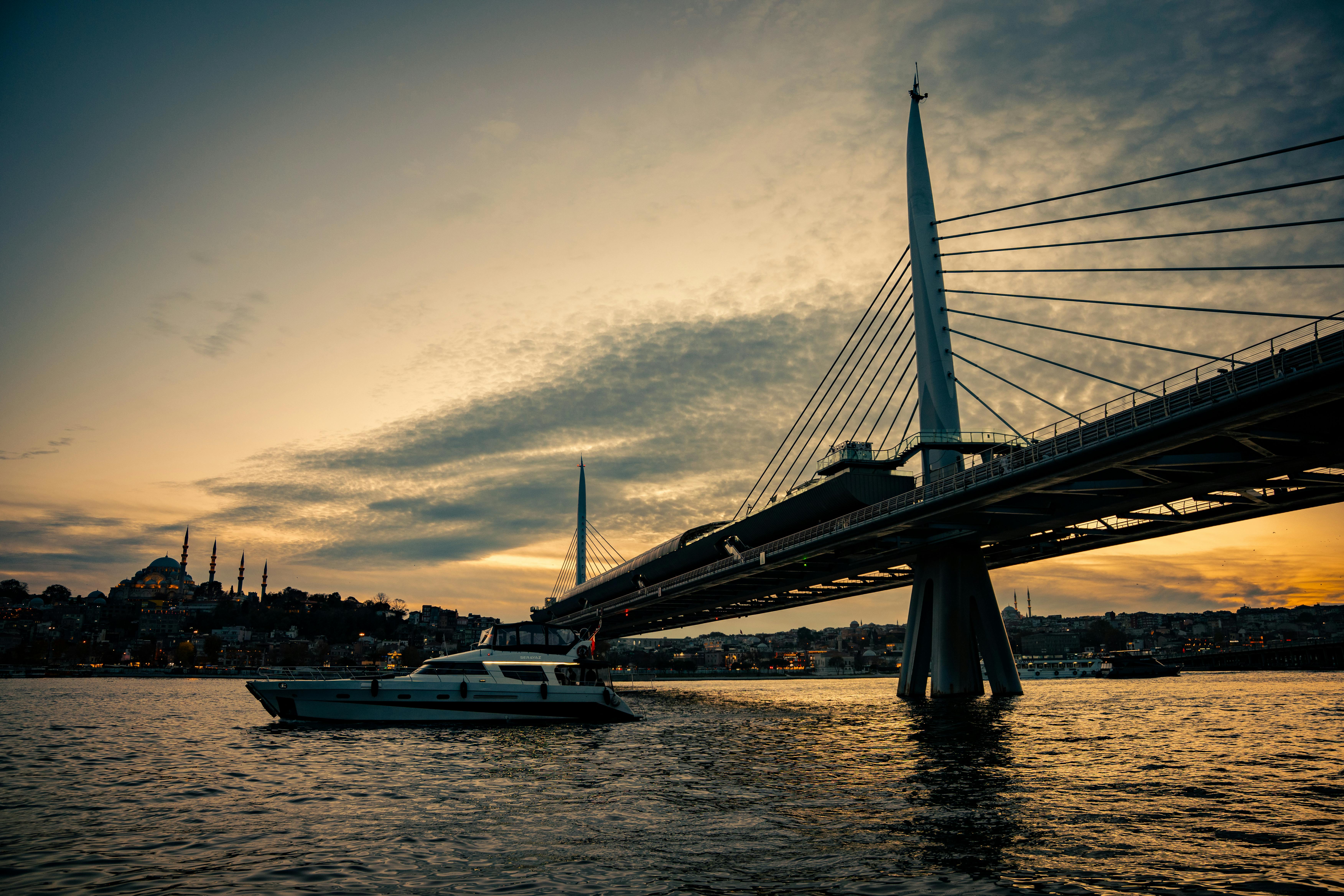 Gratuit Admirez le magnifique coucher de soleil sur le pont du métro de la Corne d'Or à Istanbul, avec un bateau qui passe à proximité. Photos