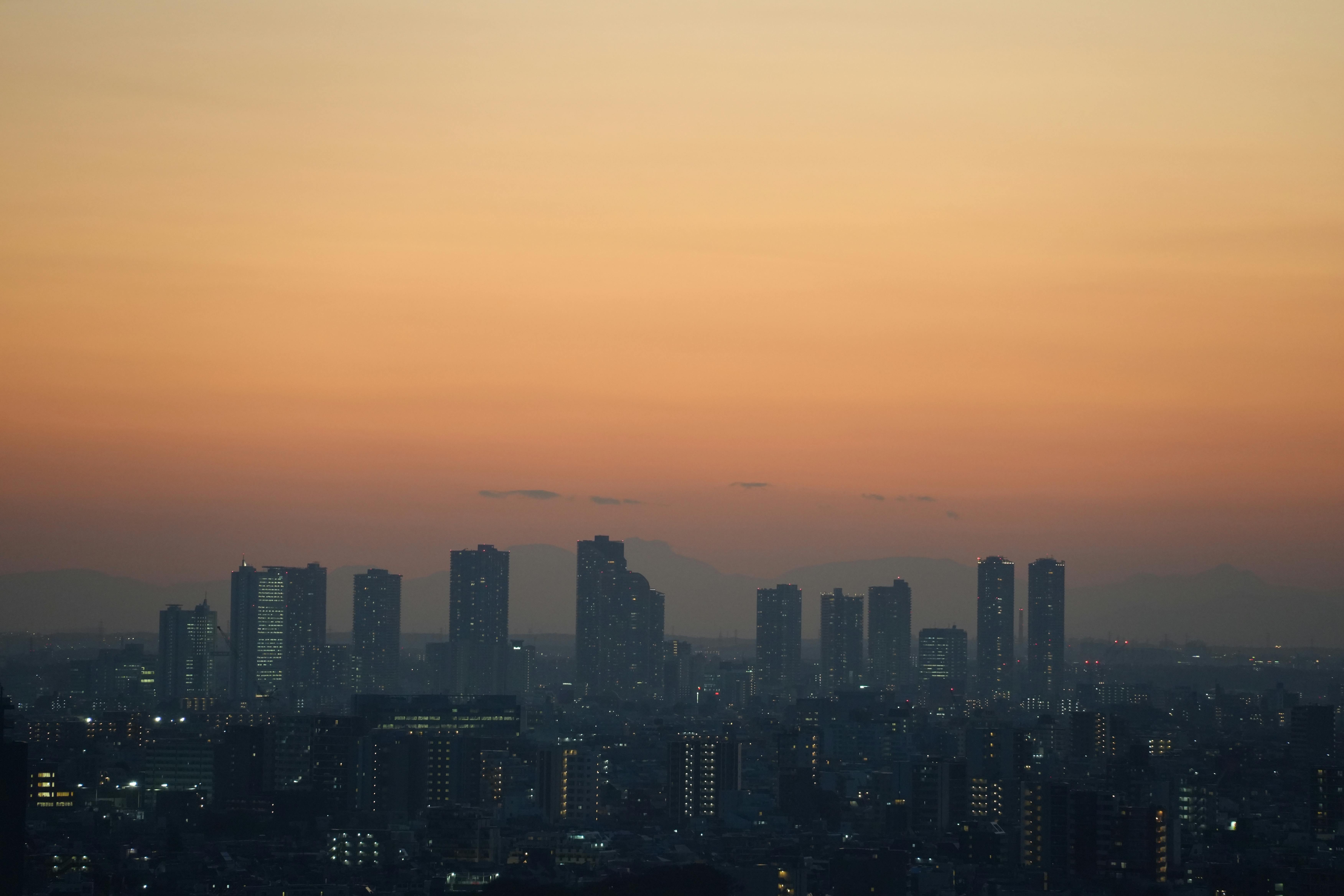 Stunning view of Tokyo skyscrapers silhouetted against a vibrant sunset sky at dusk.