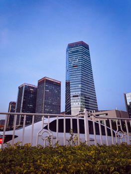View of towering skyscrapers against a clear evening sky in a bustling urban setting.