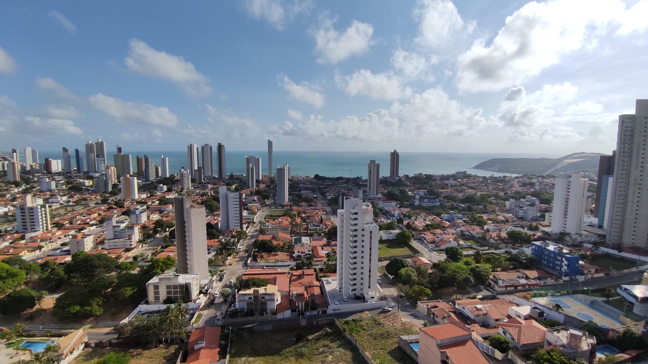 Aerial view of Natal, Brazil showcasing the skyline and Ponta Negra Beach under a sunny sky.