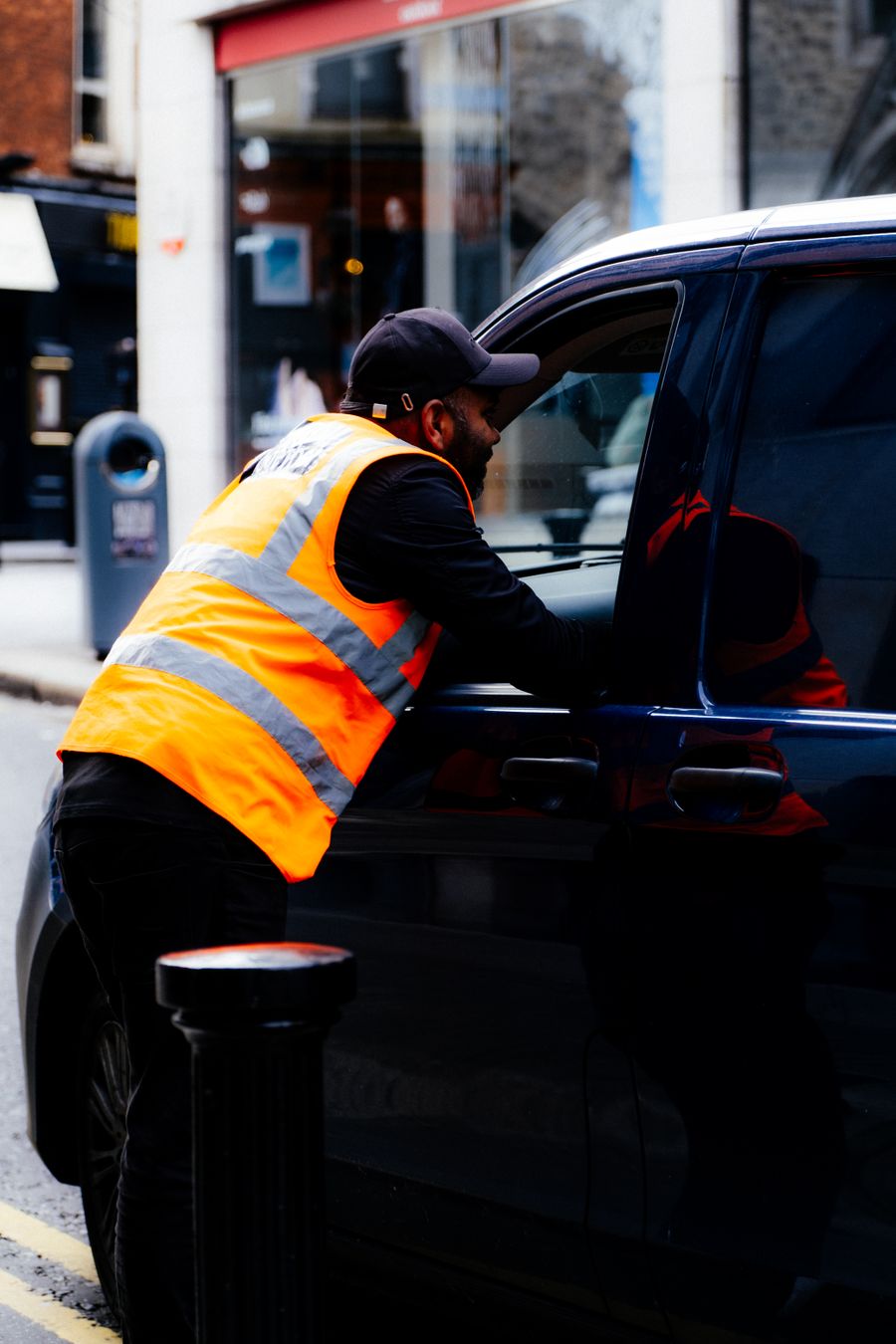 Attendant assisting with vehicle traffic outside an office building