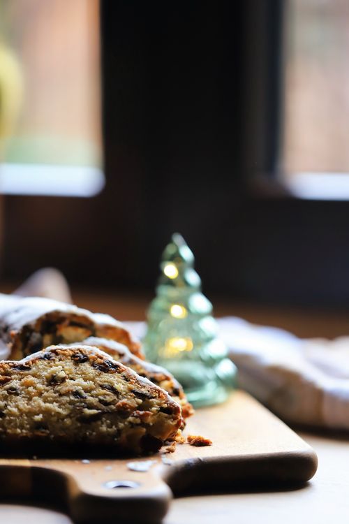 Free Close-up of traditional stollen bread with almonds and raisins, festive lights in background. Stock Photo