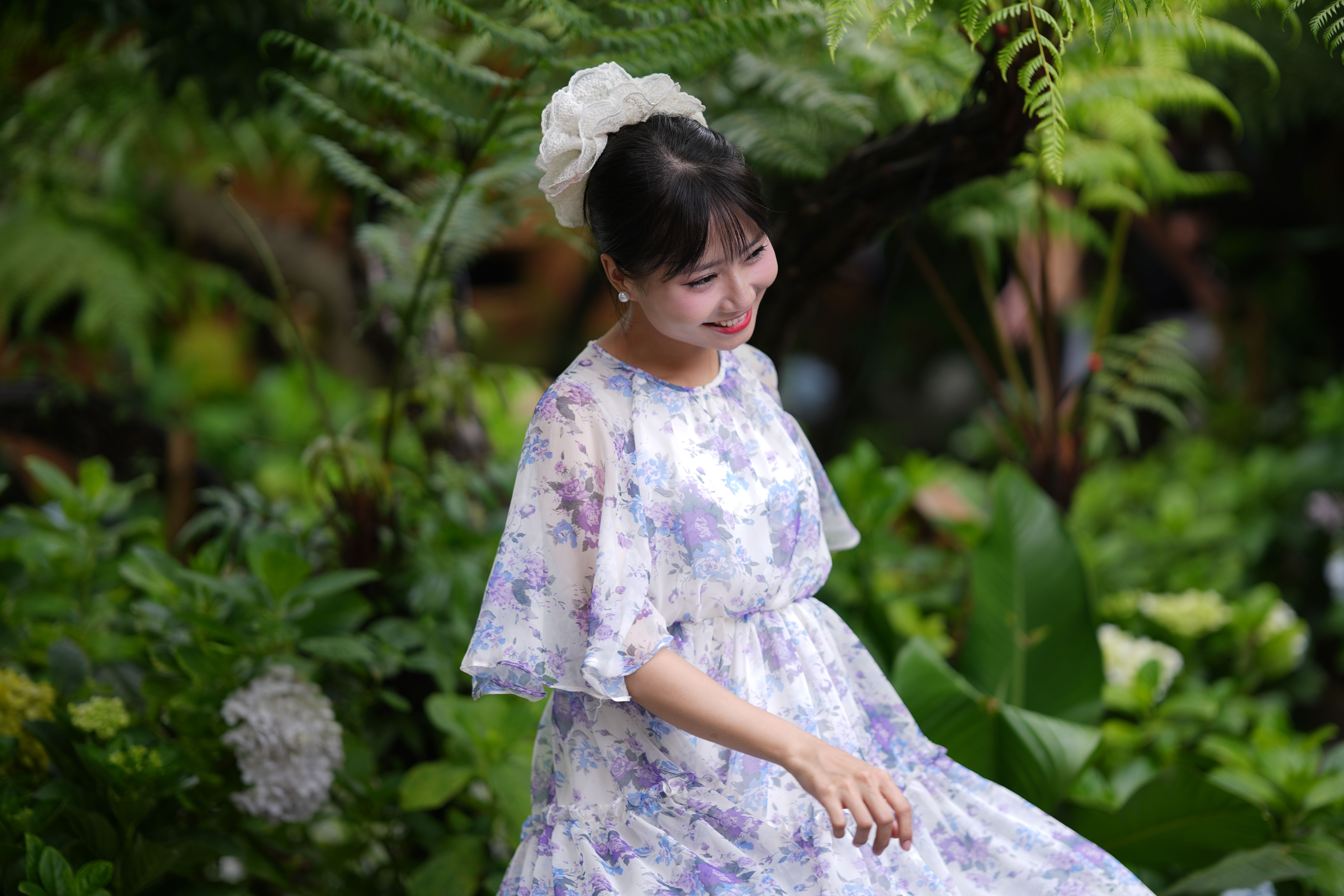 Joyful Woman in Floral Dress in Lush Garden Setting · Free Stock Photo