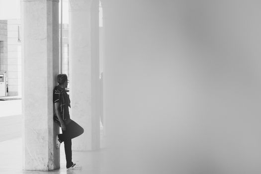 Monochrome portrait of a person leaning against a pillar in Rabat, Morocco.