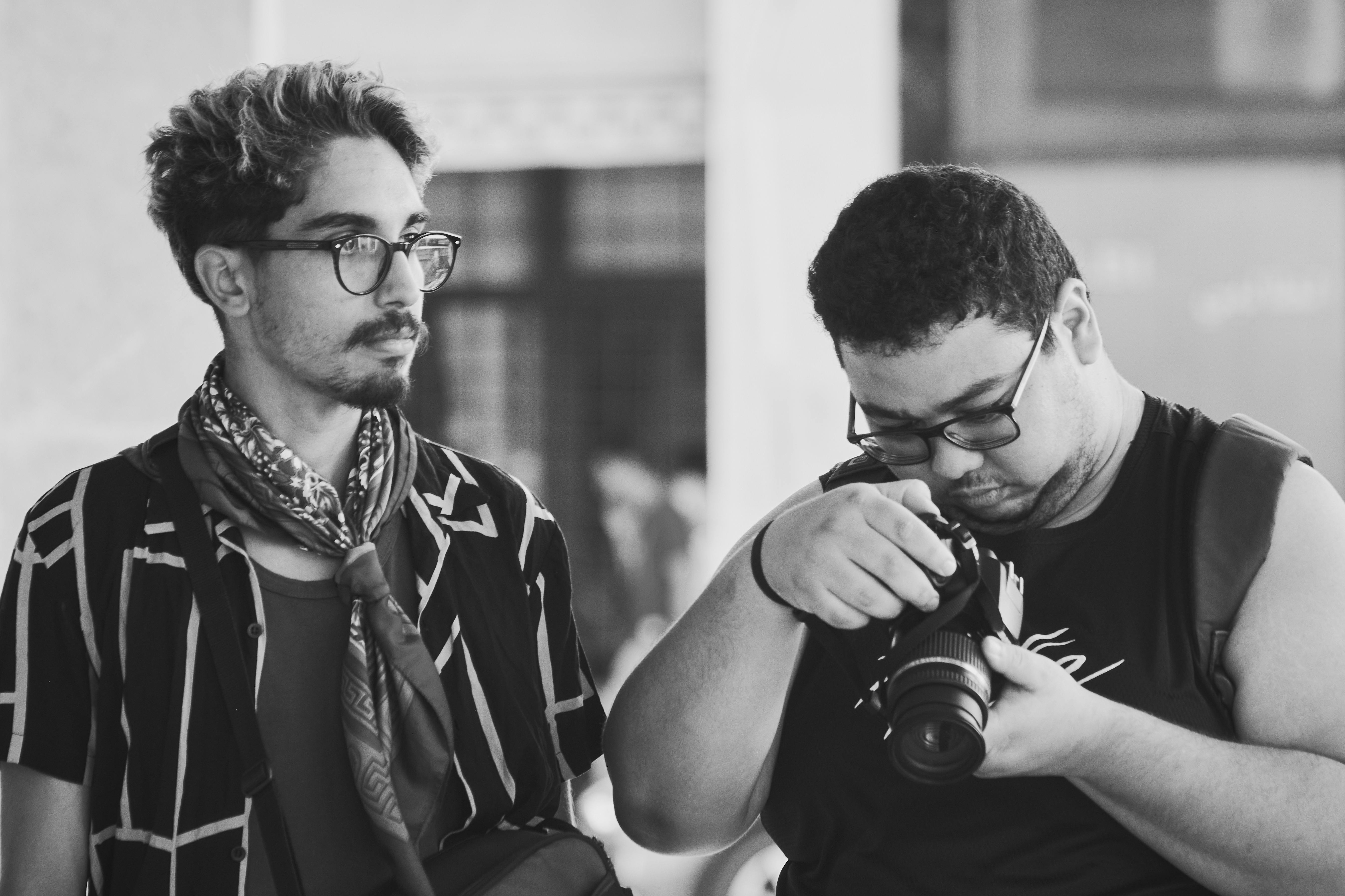 Monochrome image of two photographers interacting with a camera indoors in Rabat, Morocco.